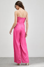 Load image into Gallery viewer, Our Above Status Satin Jumpsuit perfect blend of sophistication and texture that adds a touch of elegance to your wardrobe. This satin jumpsuit features a cowl neck design with intricate trim detailing, meticulously woven to create a unique and visually captivating ensemble.
