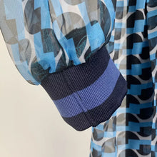 Load image into Gallery viewer, This dress is everything babe! From the vibrant color blue wave pattern. We're literally obsessed with this dress! This gorgeous sheer statement dress has a mini lining underneath. Featuring a round crewneck line, back button closure, sheer material, cut out side design. You can pair it with a red or transparent high heels and mini bag for a standout look that'll have all eyes on you!