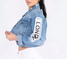 Load image into Gallery viewer, Update your denim collection with our cropped jacket we are obsessing over. Featuring a mid wash denim material with a raw edge and a cropped length, double up your denim with our matching mid-wash jeans and a nude crop top for a combo that can be dressed up or down.