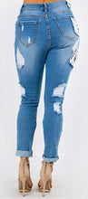 Load image into Gallery viewer, We are obsessing over these distressed mid rise jeans. Featuring a trendy medium wash denim, distressed and, patchwork features. Make these jeans your go-to to when putting together the perfect outfit. Pair these jeans with a statement top and our favorite transparent heels for a look we&#39;re loving. 
