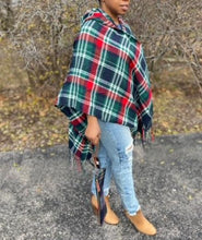 Load image into Gallery viewer, Drape yourself in style and warmth with our pretty Giving You Everything poncho featuring warm material plaid patterned with a roomy hood, open sides, and an ultra-draped silhouette that falls into an uneven knee-length hemline with fringe trim detailing!