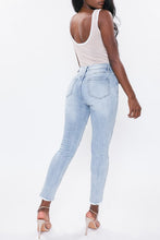 Load image into Gallery viewer, If you don't have this closet essential, you are missing out! These high rise, distressed denim medium wash, skinny jeans are a must have! They feature two back, two front pockets and a front zipper and button to close, distressed details to have you styling at the top of your game. We love pairing our denim distressed jeans with heels for a classier look or with some booties to bring some edge!