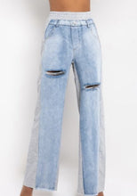 Load image into Gallery viewer, In The Mix Denim Sweatpants. These bottoms are made from a mix of heather grey cotton sweat and light wash denim fabrication. These pants feature distressed rips at the knees, straight leg pants, an elastic waistband, two front and back pockets, and a button detail. Style these with a cropped hoodie and a pair of white sneakers!