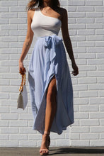 Load image into Gallery viewer, This one shoulder white &amp; blue striped maxi dress with slit is so beautiful! We love the striped design, one shoulder style and a side slit. Great for any upcoming semi formal events or even just simply to run errands. Picture yourself on vacation with this beautiful maxi, you&#39;ll definitely turn heads! Pair with a simple high heel, gold accessories and handbag for a complete look.
