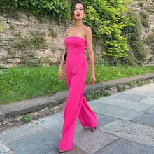 Load image into Gallery viewer, No matter the occasion, the All Inclusive Strapless Jumpsuit is sure to impress! Featuring a hugging figure with an invisible zip closure at back, princess-seamed bodice with an elasticized back, strapless and welt pockets detailing. This endless strapless pink jumpsuit in classic solid color is perfect from day to night. Complete it with a mini clutch and heels for a sophisticated look.