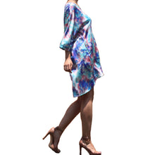 Load image into Gallery viewer, Dipped N' Sunset - Blue Pryceless Angels we're obsessing over this tie dye high low mini print dress! You can wear it from work to a night out, this dress is super versatile for multiple occasions! This loose fitting dress has a soft satin feel featuring two side pockets a multicolored tie dye print, V- Neck, you definitely need this in your new season collection. Pair with a strappy blue, pink or transparent high heels and clutch for a complete look.