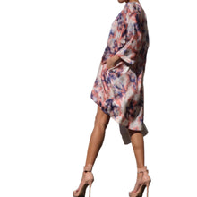 Load image into Gallery viewer, Dipped N' Sunset - Peach Pryceless Angels we're obsessing over this tie dye high low mini print dress! You can wear it from work to a night out, this dress is super versatile for multiple occasions! This loose fitting dress has a soft satin feel featuring two side pockets a multicolored tie dye print, V- Neck, you definitely need this in your new season collection. Pair with a strappy peach, pink or transparent high heels and clutch for a complete look.