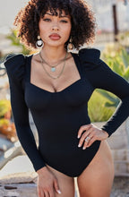 Load image into Gallery viewer, You're sure to turn a head and drop a jaw with this puff-sleeved bodysuit. It's perfect for adding to any outfit of the day. Featuring a black stretchy ribbed material with puff long-sleeves, Sweetheart neckline, padded cups, and attached thong bottoms with snap closures. Team it with some light wash jeans, cute high heels, layered jewelry, and a clutch purse for a fun and flirty look.