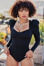 Load image into Gallery viewer, You're sure to turn a head and drop a jaw with this puff-sleeved bodysuit. It's perfect for adding to any outfit of the day. Featuring a black stretchy ribbed material with puff long-sleeves, Sweetheart neckline, padded cups, and attached thong bottoms with snap closures. Team it with some light wash jeans, cute high heels, layered jewelry, and a clutch purse for a fun and flirty look.