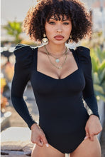 Load image into Gallery viewer, You're sure to turn a head and drop a jaw with this puff-sleeved bodysuit. It's perfect for adding to any outfit of the day. Featuring a black stretchy ribbed material with puff long-sleeves, Sweetheart neckline, padded cups, and attached thong bottoms with snap closures. Team it with some light wash jeans, cute high heels, layered jewelry, and a clutch purse for a fun and flirty look.