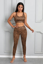 Load image into Gallery viewer, Stand out from the crowd with a sexy pop of print to inspire your new moves. Work out in style with this eye-catching leopard print workout set that comes with a racerback sports bra and high-rise leggings. This style looks great back with the matching tight and a cut out back top to show off the back strap detail. Moisture wicking and breathable, you'll feel cool, comfortable and stylish. This set is perfect if you want to look stylish while working out in gym or studio.