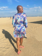 Load image into Gallery viewer, Pryceless Angels we're obsessing over this tie dye high low mini print dress! You can wear it from work to a night out, this dress is super versatile for multiple occasions! This loose fitting dress has a soft satin feel featuring two side pockets a multicolored tie dye print, V- Neck, you definitely need this in your new season collection. Pair with a strappy blue, pink or transparent high heels and clutch for a complete look.