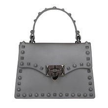Load image into Gallery viewer, Are you ready to make a statement, babe? This rubberized trendy bag features a soft matte sage finish, studded detailing, gunmetal hardware with a locking clasp, a roomy interior compartment and also includes a crossbody strap. It's time to bring some edge and ambition to your look, sis!