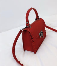 Load image into Gallery viewer, Are you ready to make a statement, babe? This rubberized trendy bag features a soft matte sage finish, studded detailing, gunmetal hardware with a locking clasp, a roomy interior compartment and also includes a crossbody strap. It's time to bring some edge and ambition to your look, sis!