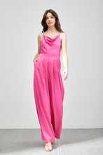 Load image into Gallery viewer, Our Above Status Satin Jumpsuit perfect blend of sophistication and texture that adds a touch of elegance to your wardrobe. This satin jumpsuit features a cowl neck design with intricate trim detailing, meticulously woven to create a unique and visually captivating ensemble.
