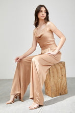 Load image into Gallery viewer, Our Above Status Satin Jumpsuit perfect blend of sophistication and texture that adds a touch of elegance to your wardrobe. This satin jumpsuit features a cowl neck design with intricate trim detailing, meticulously woven to create a unique and visually captivating ensemble.
