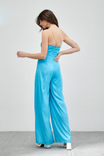 Load image into Gallery viewer, Our Above Status Satin Jumpsuit perfect blend of sophistication and texture that adds a touch of elegance to your wardrobe. This satin jumpsuit features a cowl neck design with intricate trim detailing, meticulously woven to create a unique and visually captivating ensemble.
