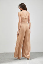 Load image into Gallery viewer, Our Above Status Satin Jumpsuit perfect blend of sophistication and texture that adds a touch of elegance to your wardrobe. This satin jumpsuit features a cowl neck design with intricate trim detailing, meticulously woven to create a unique and visually captivating ensemble.
