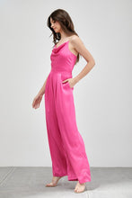 Load image into Gallery viewer, Our Above Status Satin Jumpsuit perfect blend of sophistication and texture that adds a touch of elegance to your wardrobe. This satin jumpsuit features a cowl neck design with intricate trim detailing, meticulously woven to create a unique and visually captivating ensemble.
