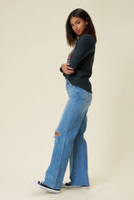 Load image into Gallery viewer, Our New Favorite Vibrant M.i.U Distressed Wide Fit Jeans featuring classic 5-pocket construction, front knee cut details, raw-edged hem, tinted wash throughout, and a zip-fly closure. These jeans are a must-have for your wardrobe this season. Pair with one of our essential bodysuits, pumps, or sneakers and a jacket for effortless style. 
