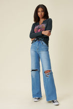 Load image into Gallery viewer, Our New Favorite Vibrant M.i.U Distressed Wide Fit Jeans featuring classic 5-pocket construction, front knee cut details, raw-edged hem, tinted wash throughout, and a zip-fly closure. These jeans are a must-have for your wardrobe this season. Pair with one of our essential bodysuits, pumps, or sneakers and a jacket for effortless style. 
