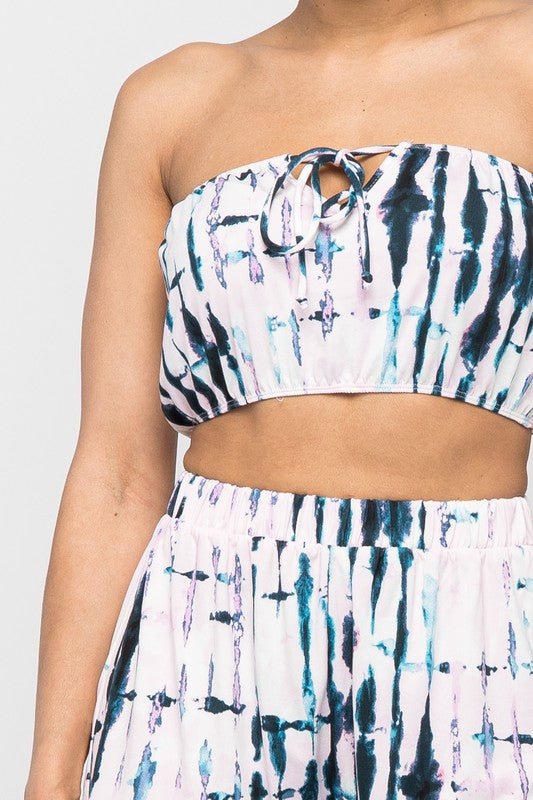 Keep it totally trendy in tie dye and get in touch with your playful side! This multi color crop top features a strapless neckline and a elastic band hem. The vibrant blues, pink, and lilac and compose a fun tie dye pattern. Pair this set with a simple high heels, silver accessories and mini bag for a complete look. 