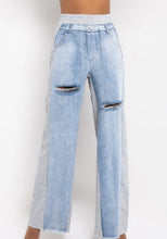 Load image into Gallery viewer, In The Mix Denim Sweatpants. These bottoms are made from a mix of heather grey cotton sweat and light wash denim fabrication. These pants feature distressed rips at the knees, straight leg pants, an elastic waistband, two front and back pockets, and a button detail. Style these with a cropped hoodie and a pair of white sneakers!
