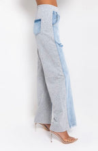 Load image into Gallery viewer, In The Mix Denim Sweatpants. These bottoms are made from a mix of heather grey cotton sweat and light wash denim fabrication. These pants feature distressed rips at the knees, straight leg pants, an elastic waistband, two front and back pockets, and a button detail. Style these with a cropped hoodie and a pair of white sneakers!
