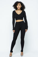Load image into Gallery viewer, This Just Chill Set is every wardrobe essential. Featuring a black rib kitted fabric with a V neckline top with long sleeves, high rise pants with soft elasticized waistband, lightweight material. Style with a high heel or boots and handbag for a weekend look you&#39;ll love! 
