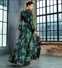 Load image into Gallery viewer, Make a bold statement for day in the town or a night out with the girls with our jungle leaf print long train romper. This romper features long full sleeves, a plunge V-neckline, and a long tail that drapes in the back to the floor. Make every head turn from every angle, this look is perfect for the fashionista who always comes and slays their look every time.
