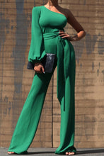 Load image into Gallery viewer, One Shoulder Jumpsuit - Dark Green This jumpsuit is a statement in itself! Perfect for all of your summer fun! This green jumpsuit comes in a wide pant leg featuring a long sleeve one shoulder, adjustable tie belt, and side zipper. Pair this with a stylish heel and handbag for a complete look.
