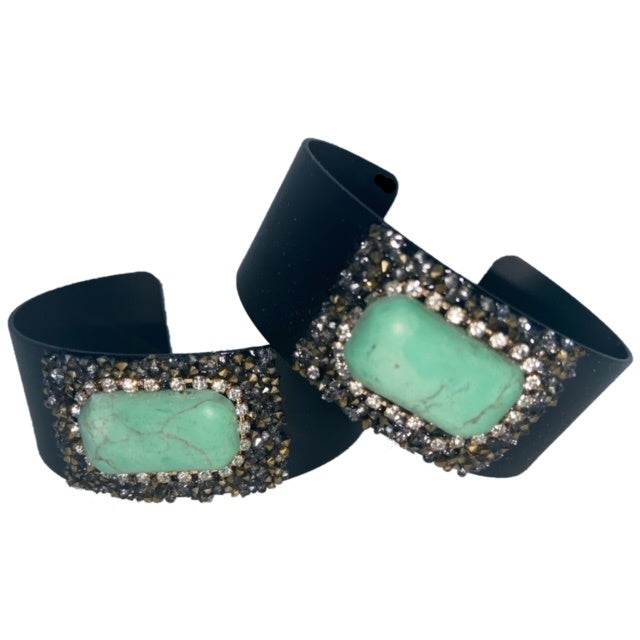 Give your outfit of the day the perfect finishing touch with this turquoise rhinestone black cuff. Featuring a black medal cuff with turquoise stone detailed with rhinestones. Is slightly adjustable.