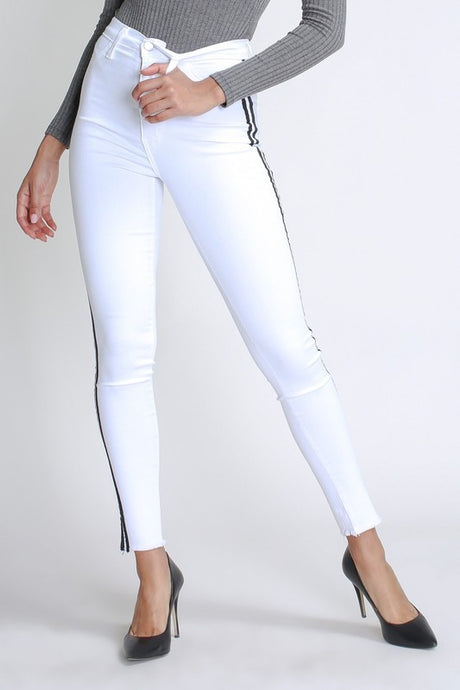 Flex your style in these cute white skinny Jeans with a contrast black stripe designs. Perfect for styling any and every way you want! These jeans come in a high rise fit featuring a raw uneven hem ends, zip and button closure. Pair with a graphic tee or chic fashion top, high heels or combat boots and of course a handbag for a complete look!