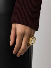 Load image into Gallery viewer, Inspired by sculpture from the Pop Art movement, this cocktail ring is playfully and unexpectedly soft in shape. A single precision cut Champane crystal is cushioned in a glossy molded setting and finished with a tonal band and brass inlay. For a striking statement wear yours alone. 
