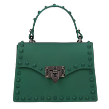 Load image into Gallery viewer, Are you ready to make a statement, babe? This rubberized trendy bag features a soft matte sage finish, studded detailing, gunmetal hardware with a locking clasp, a roomy interior compartment and also includes a crossbody strap. It&#39;s time to bring some edge and ambition to your look, sis!
